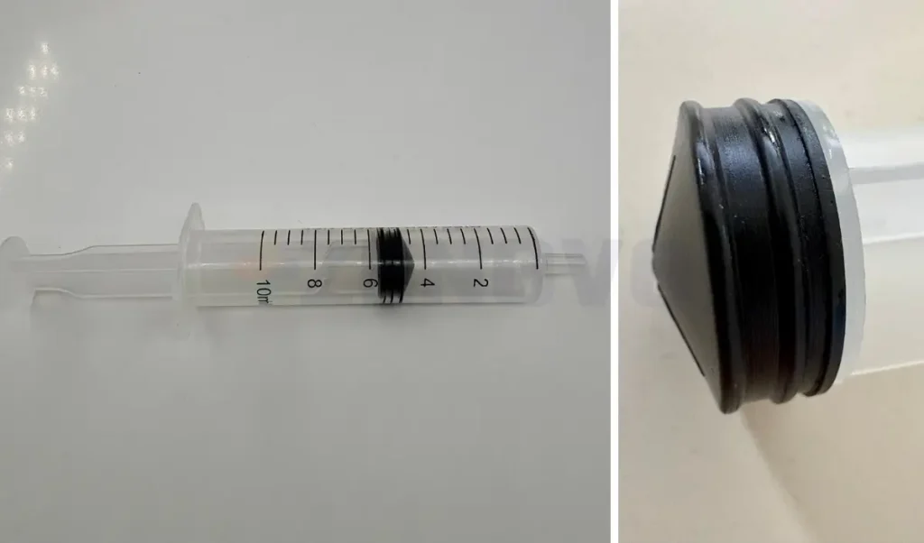 Detaliu macro al garniturii negre a pistonului unei seringi, indicând linia corectă pentru măsurarea dozei.