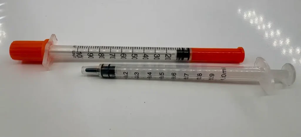 Comparație între scala unei seringi de insulină U-100 în unități și o seringă de tuberculină gradată în mililitri.